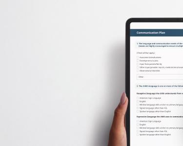A hand holds a tablet displaying a communication plan form, with sections for language preferences and communication methods.