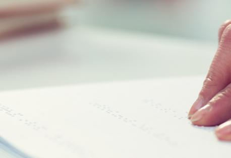 Closeup of hands reading braille.
