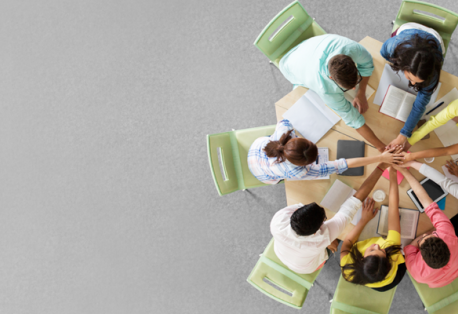 Overhead view of several students sitting together at a round table.