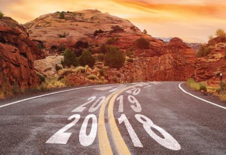 A winding road in a desert setting; years are written in the middle of the road in ascending order.