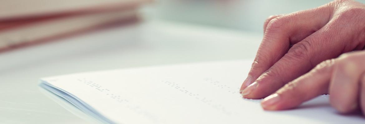 Closeup of hands reading braille.