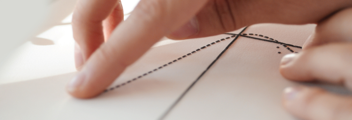 Closeup of fingers touching a tactile graphic that represents a line graph.