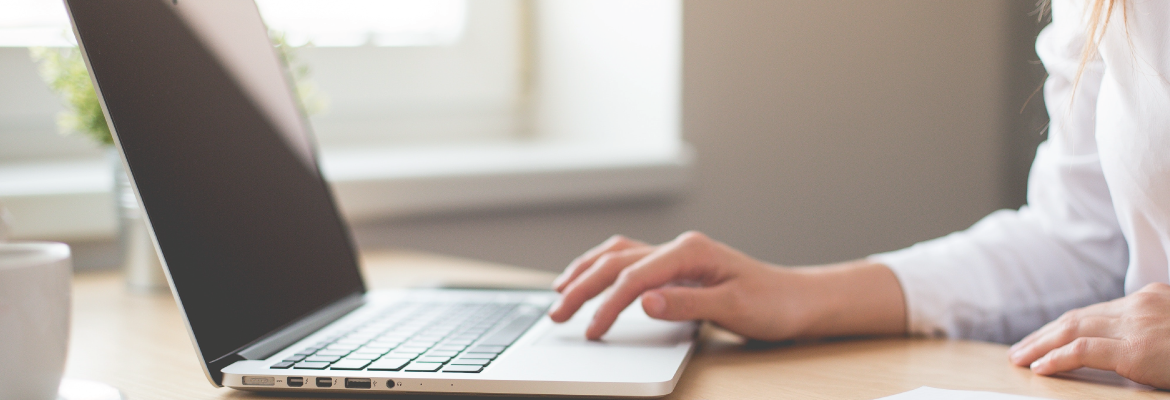 Closeup of a person touching the touchpad on an open laptop.