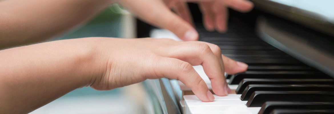 The hands of a young person on the keyboard of a piano
