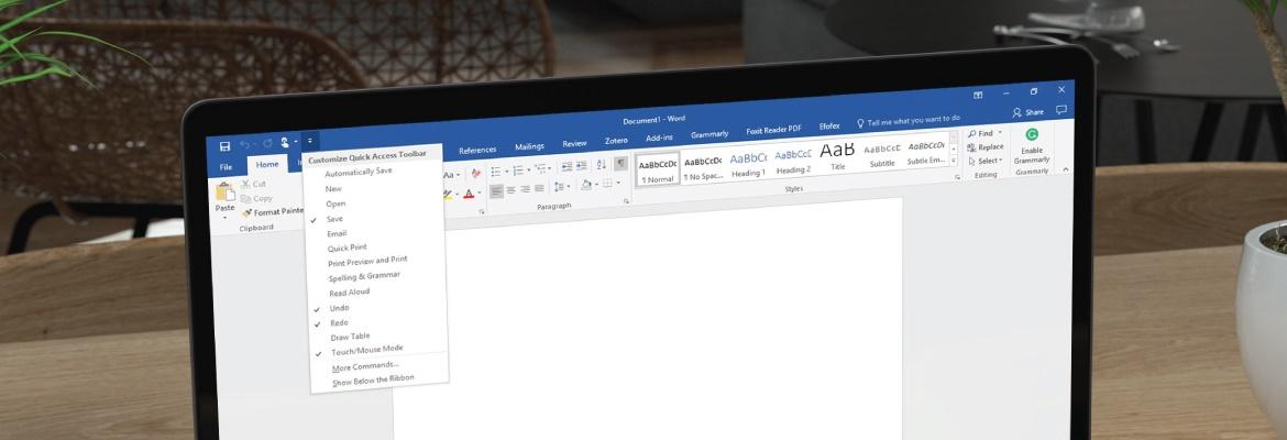 Closeup of a laptop displaying a Word document with the Quick Access Toolbar open.