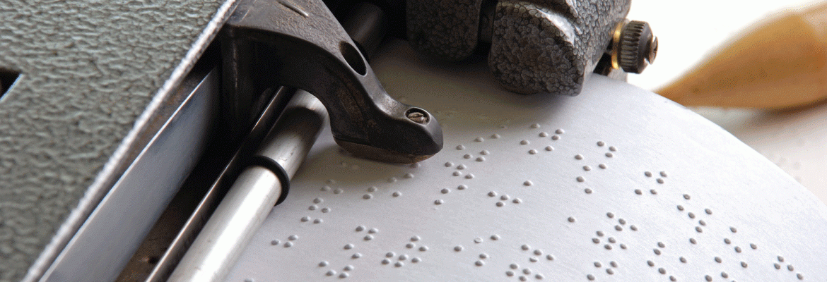 Closeup of a braille writer embossing braille onto a page.