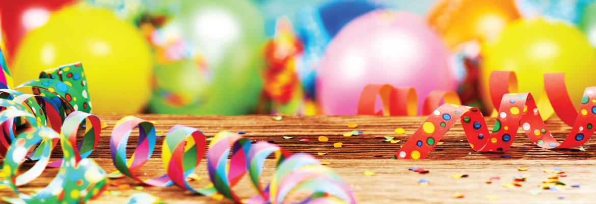 Bright, multicolored spiral party streamers and balloons.