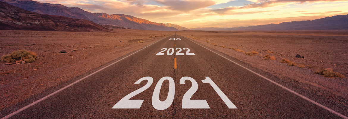 A straight two-way road stretching out into the distance in a desert; the years 2021, 2022, and 2023 are printed on the road.
