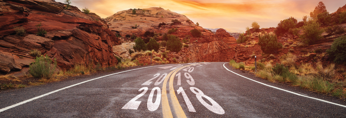 A winding road in a desert setting; years are written in the middle of the road in ascending order.