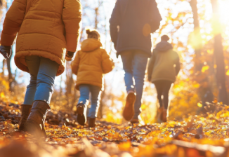 A group of school age kids hiking on a trail in autumn. 