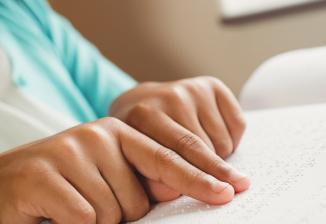 Closeup of a girl reading braille.